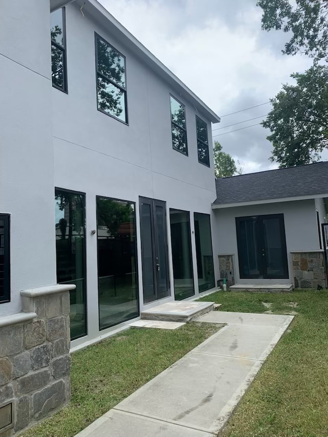 4814 Locust St, Bellaire, TX 77401 - back of house featuring stucco siding, a shingled roof, a yard, and french doors