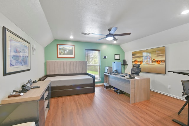 office featuring vaulted ceiling, a textured ceiling, hardwood / wood-style floors, and ceiling fan