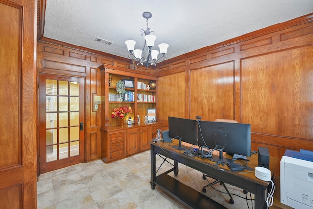 office with ornamental molding, a textured ceiling, a chandelier, and wooden walls