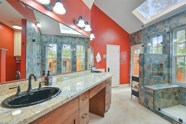 bathroom with vanity, lofted ceiling with skylight, and a shower with door