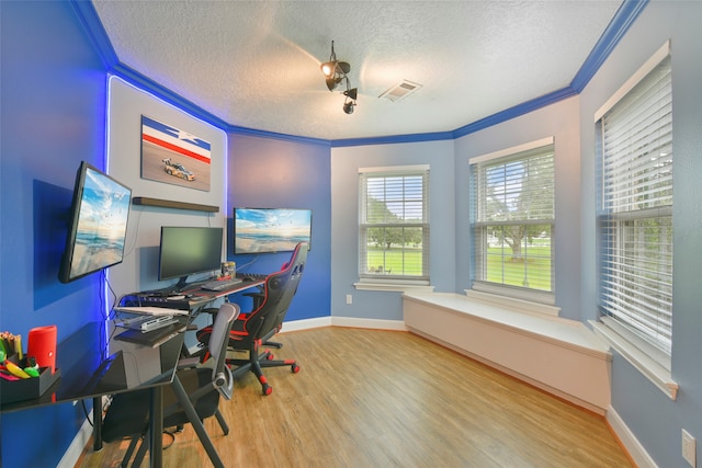 office featuring a textured ceiling, crown molding, and light wood-type flooring