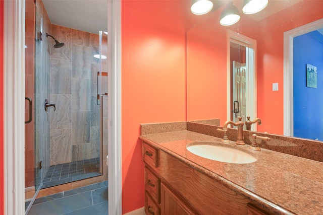 bathroom with tile patterned floors, a shower with door, and vanity