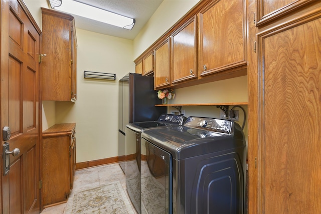 laundry room with cabinets, independent washer and dryer, and light tile patterned flooring