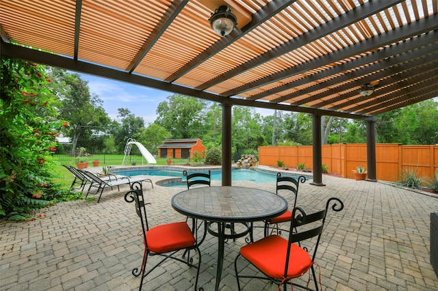 view of patio / terrace with a pergola, a fenced in pool, and a storage shed