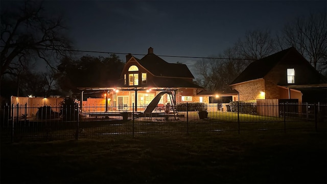 back house at twilight with a lawn