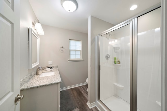 bathroom with vanity, toilet, hardwood / wood-style flooring, and walk in shower