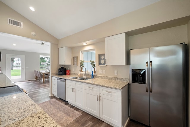 kitchen featuring white cabinets, appliances with stainless steel finishes, hardwood / wood-style floors, and vaulted ceiling