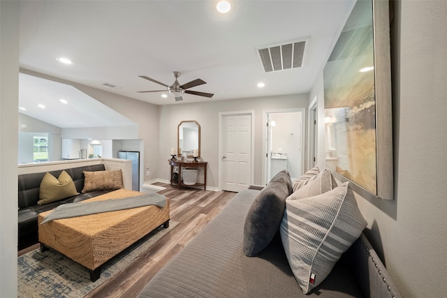 bedroom featuring ceiling fan, ensuite bath, and hardwood / wood-style flooring