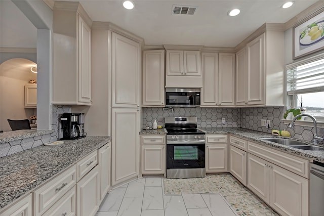 kitchen featuring crown molding, appliances with stainless steel finishes, light stone counters, sink, and decorative backsplash