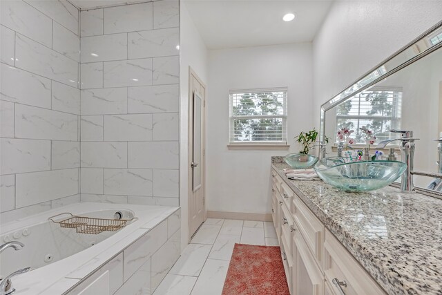 bathroom featuring tiled bath and vanity