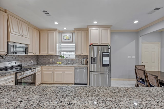 kitchen with cream cabinetry, appliances with stainless steel finishes, tasteful backsplash, and sink