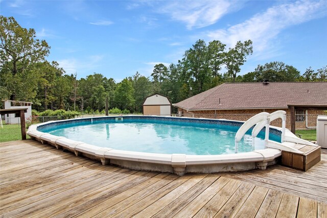 view of pool featuring an outbuilding and a deck