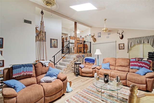 living room featuring lofted ceiling with beams, a textured ceiling, wood-type flooring, and ceiling fan