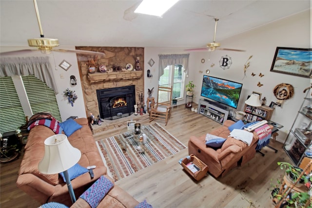 living room featuring a fireplace, lofted ceiling, hardwood / wood-style floors, and ceiling fan