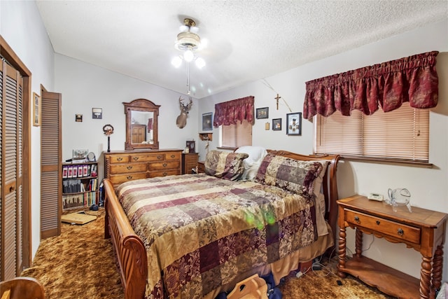 carpeted bedroom with a textured ceiling, ceiling fan, and a closet