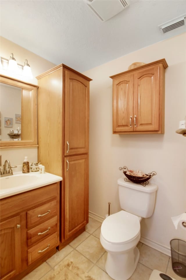 bathroom featuring tile patterned flooring, toilet, and vanity