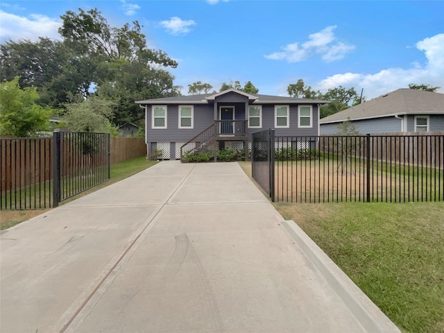 view of front facade with a fenced front yard, concrete driveway, and a front lawn