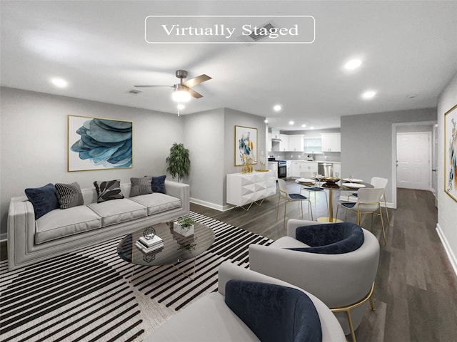 living room with dark wood-type flooring, ceiling fan, and sink