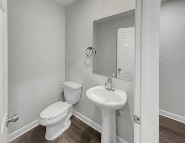 bathroom with toilet and hardwood / wood-style flooring