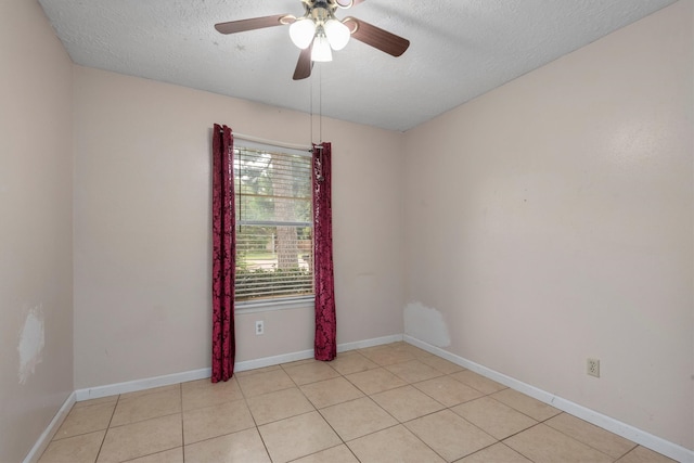 tiled empty room featuring a textured ceiling and ceiling fan