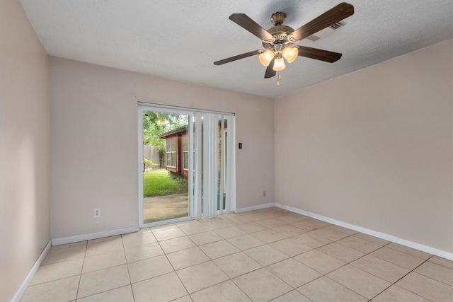 tiled empty room with a textured ceiling and ceiling fan