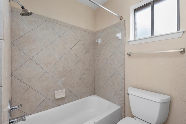 bathroom with tiled shower / bath combo and toilet