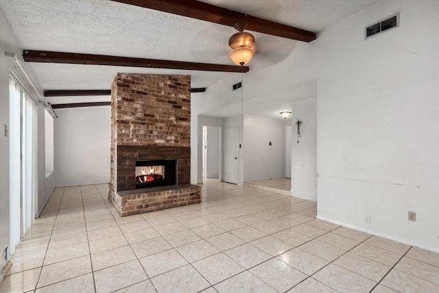 unfurnished living room featuring beamed ceiling, light tile patterned floors, and a textured ceiling