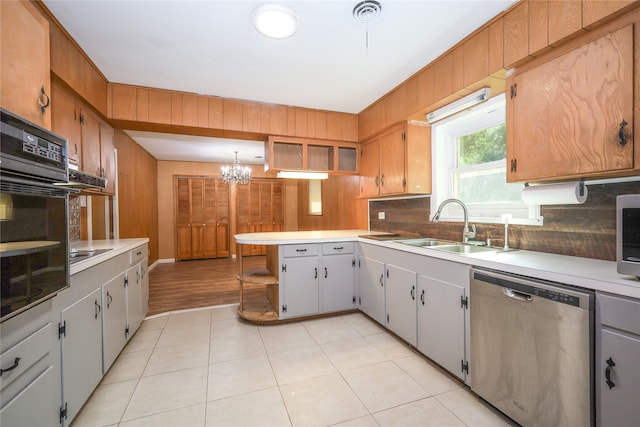 kitchen with black appliances, sink, decorative backsplash, and a chandelier