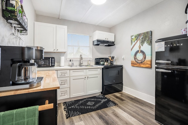 kitchen featuring black appliances, hardwood / wood-style flooring, white cabinetry, and sink