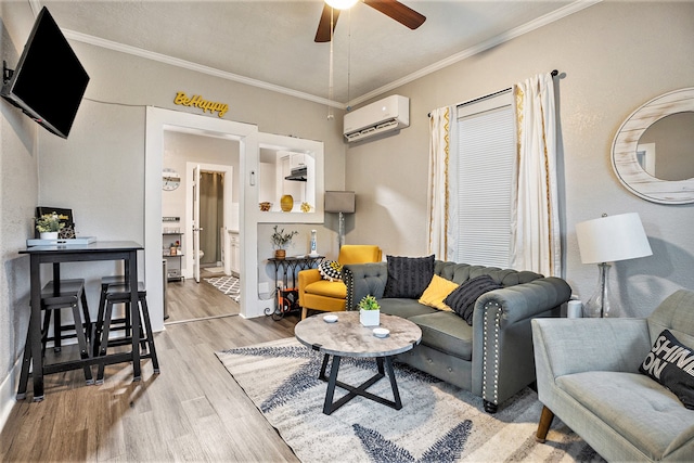 living room featuring a wall mounted AC, ceiling fan, ornamental molding, and light hardwood / wood-style flooring