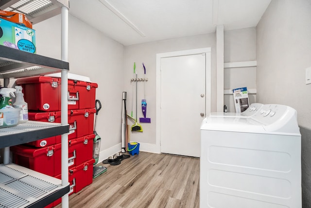 clothes washing area featuring light wood-type flooring and washer and clothes dryer