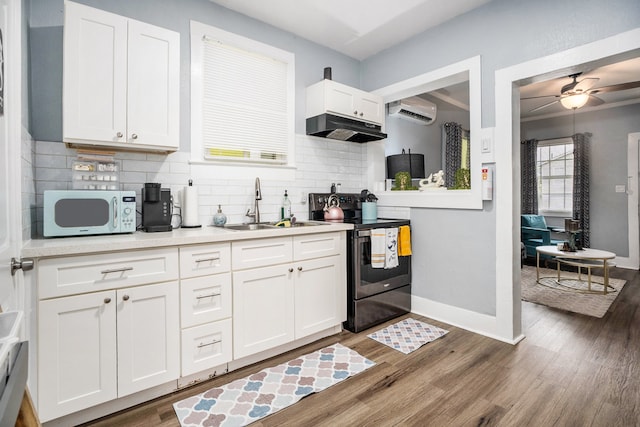 kitchen featuring a wall mounted AC, ceiling fan, dark wood-type flooring, range with electric cooktop, and white cabinets