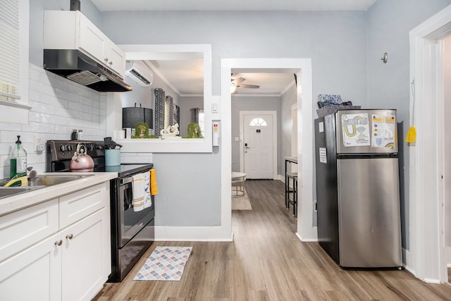 kitchen featuring light wood-type flooring, stainless steel refrigerator, ceiling fan, electric range, and white cabinets