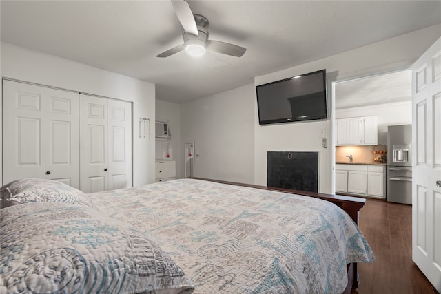 bedroom with dark hardwood / wood-style floors, sink, ceiling fan, a closet, and stainless steel fridge with ice dispenser