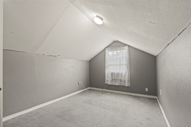 bonus room featuring lofted ceiling, a textured ceiling, and carpet floors