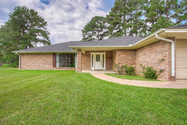 ranch-style house with a garage and a front lawn