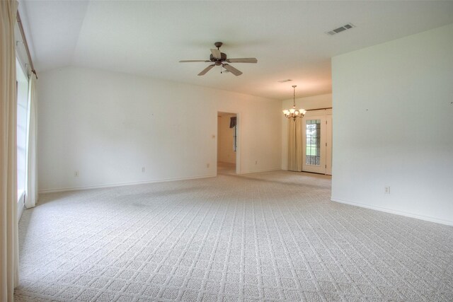 carpeted empty room with lofted ceiling and ceiling fan with notable chandelier