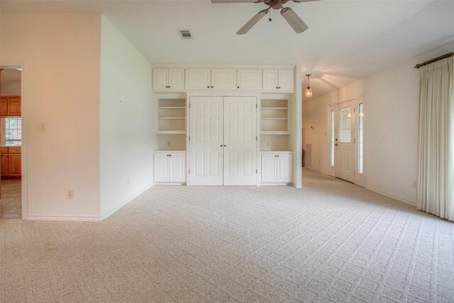 unfurnished bedroom with multiple windows, light colored carpet, and ceiling fan