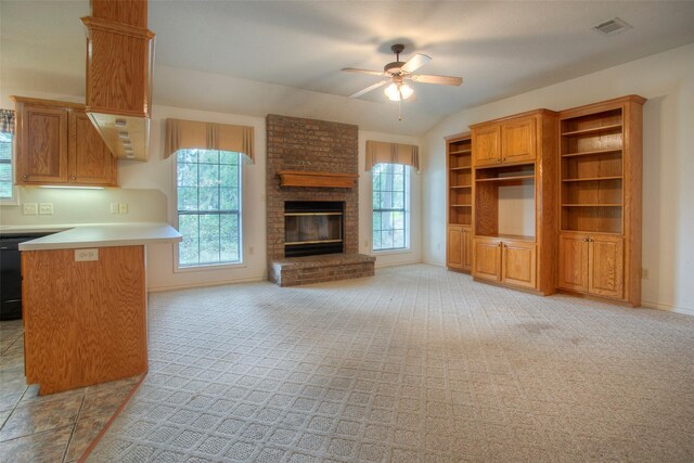 unfurnished living room with ceiling fan, a fireplace, light carpet, and vaulted ceiling