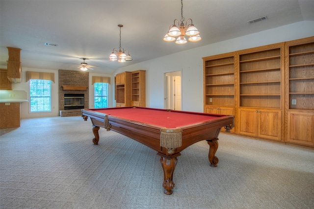 recreation room featuring pool table, ceiling fan with notable chandelier, a fireplace, light carpet, and built in shelves