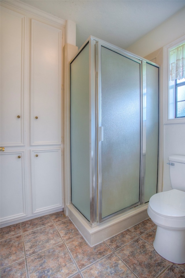 bathroom featuring an enclosed shower, toilet, and tile patterned floors