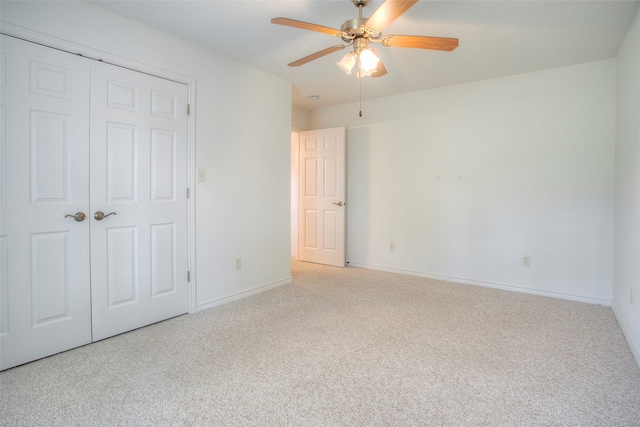 unfurnished bedroom with ceiling fan, light colored carpet, and a closet