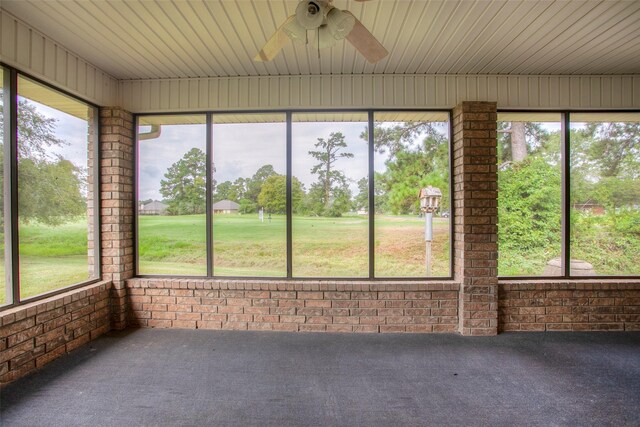 unfurnished sunroom with ceiling fan