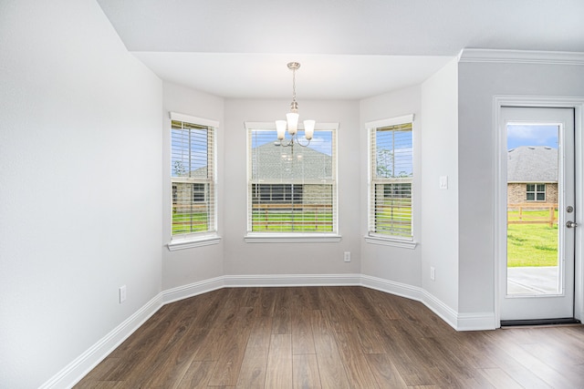 unfurnished dining area with an inviting chandelier and dark hardwood / wood-style floors