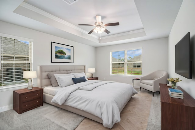 bedroom with crown molding, a raised ceiling, and light parquet floors