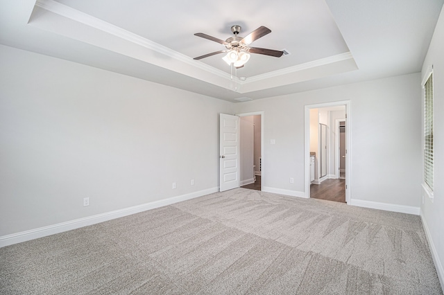 unfurnished bedroom featuring a raised ceiling, crown molding, carpet floors, and ceiling fan