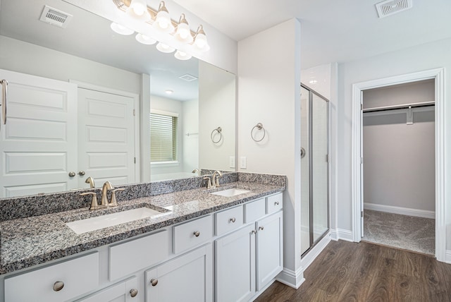 bathroom featuring a shower with door, vanity, and hardwood / wood-style floors