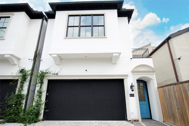 view of front of property featuring a balcony and a garage