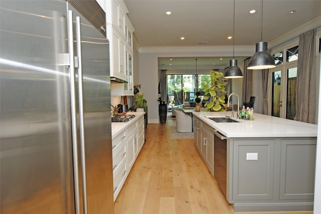 kitchen with a center island with sink, sink, appliances with stainless steel finishes, and white cabinets