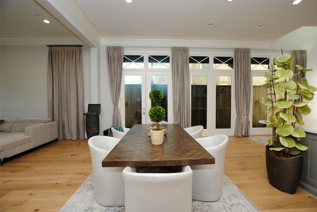 dining room featuring light wood-type flooring, french doors, and ornamental molding